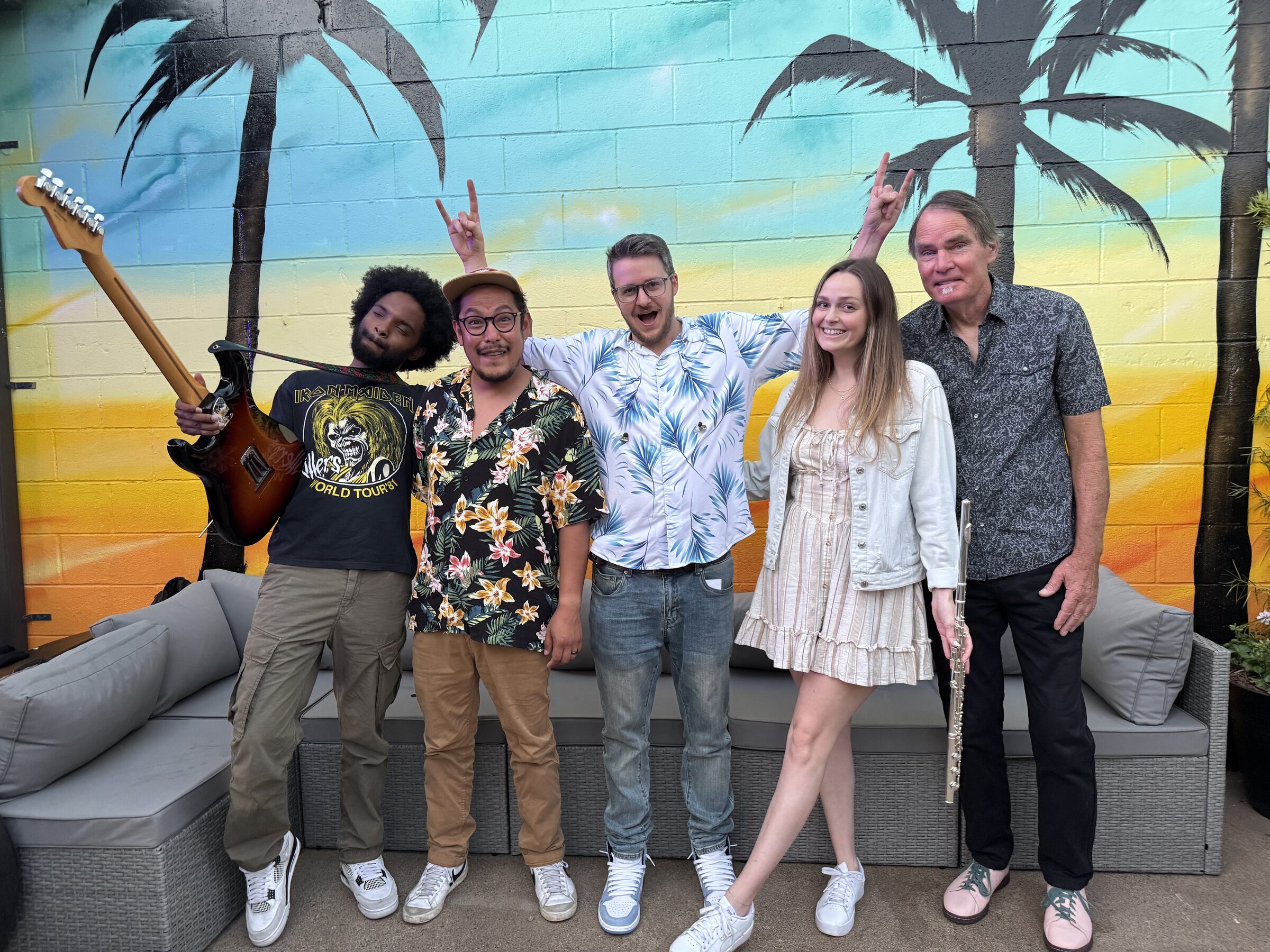 The Surf Birdz posing in front of a surf mural